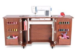 Spinning sewing machine on wooden desk with colorful thread spools and fabric toys, perfect for sewing crafts and textile projects.