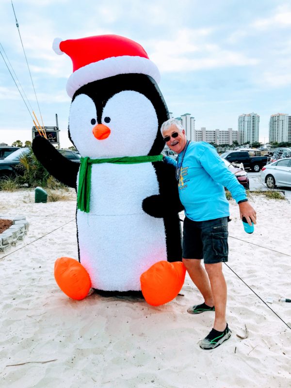 Man with large inflatable penguin