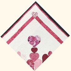 Heart-shaped pink and purple shredded paper confetti on white background, ideal for scrapbooking or crafting projects.