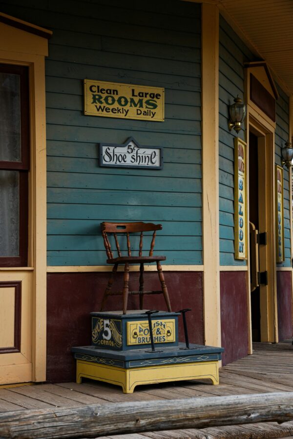 Charming vintage facade of a historic western building in Tombstone, Arizona, with signs and old wooden chair by Wart Oxana
