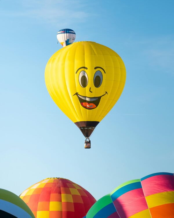 Colorful hot air balloons soar in the clear blue sky at Albuquerque Balloon Fiesta by Daniel Shapiro.