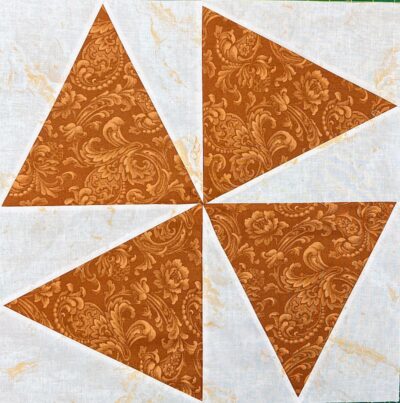 Vintage brown floral damask quilt blocks with torn white fabric accents.