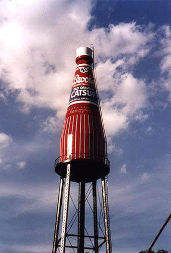 Vintage Coca-Cola billboard water tower with retro design and branding, located outdoors under a partly cloudy sky, serving as a nostalgic landmark.