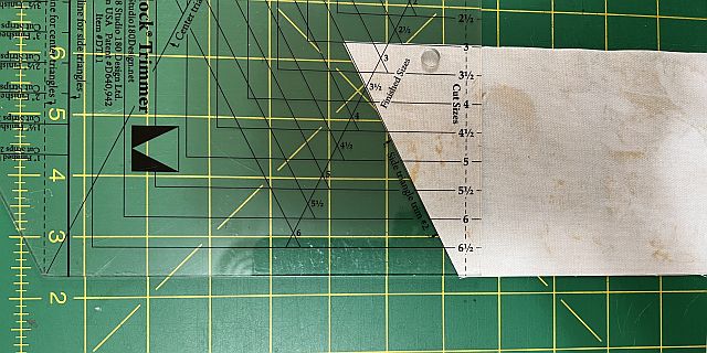 Scrapdash logo on a green cutting mat with rulers and sewing tools, emphasizing textile recycling and fabric repurposing solutions for sustainable sewing and crafting projects.